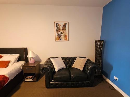 a bedroom with a black leather chair next to a bed at Robe Marina Accommodation in Robe