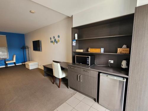 a room with a kitchen with a desk and a microwave at Robe Marina Accommodation in Robe