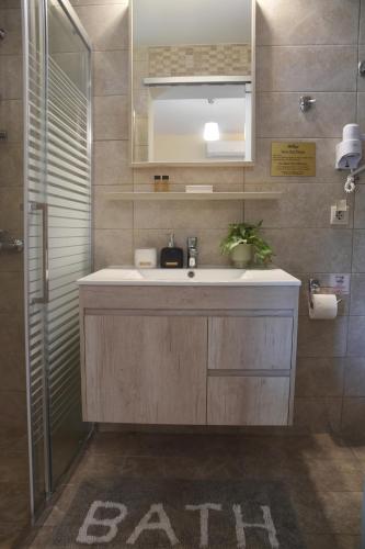 a bathroom with a sink and a mirror at Hawaii Accommodation Pelekas in Pelekas
