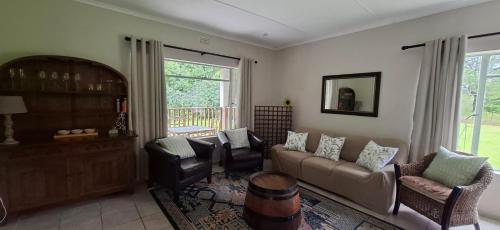 a living room with a couch and chairs at Storms River Family Accommodation in Stormsrivier