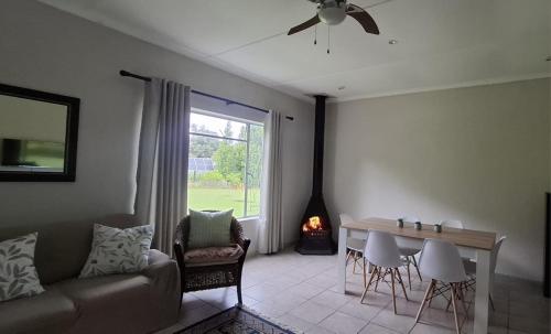 a living room with a couch and a table and a fireplace at Storms River Family Accommodation in Stormsrivier