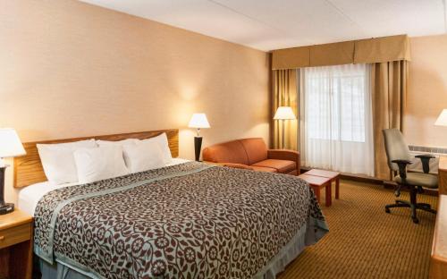 a hotel room with a bed and a chair at Days Inn by Wyndham Duluth Lakewalk in Duluth