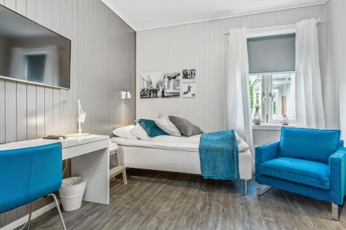a bedroom with a bed and a desk and a blue chair at Mogården in Orkanger