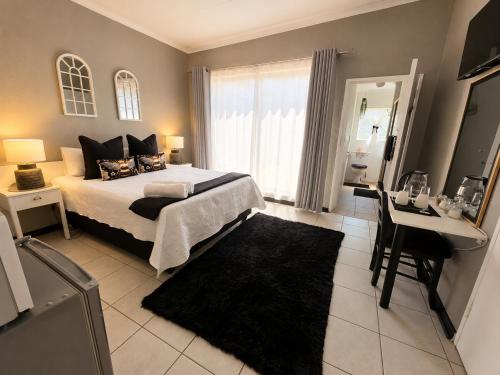 a bedroom with a bed and a table and a desk at Zhantique Guest House 2- Unit 4 in Boksburg