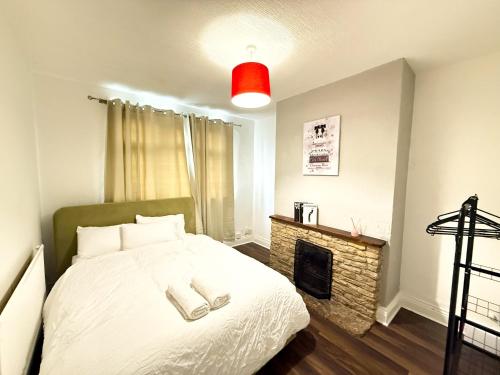 a bedroom with a bed and a fireplace at Spacious 3 Bed , Free Parking , Fast WiFi , Long Stays in Kettering