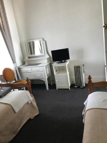 a room with two beds and a desk with a computer at Lords Hotel in Scottsdale