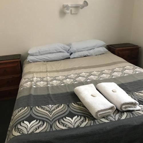 a bed with two towels on top of it at Lords Hotel in Scottsdale