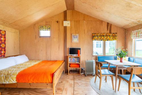 a bedroom with a bed and a table and a dining room at Bacton Beach Cabin in Bacton