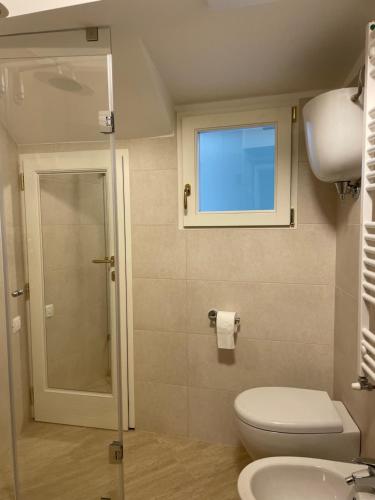a bathroom with a toilet and a sink and a window at Pinturicchio Luxury Suite in Perugia