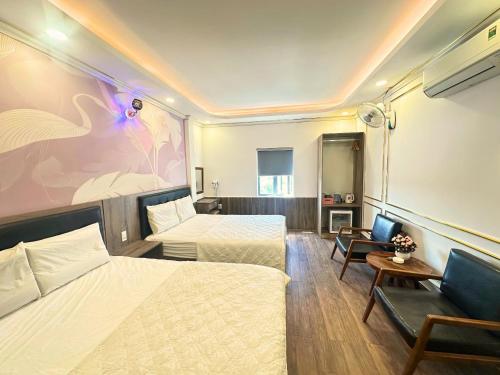 a hotel room with two beds and a couch at Love Hotel Hóc Môn in Ho Chi Minh City