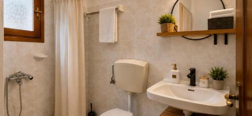 a bathroom with a white toilet and a sink at Knossos Breeze in Sitia