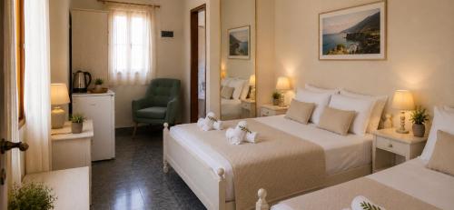 a bedroom with two white cats sitting on a bed at Knossos Breeze in Sitia
