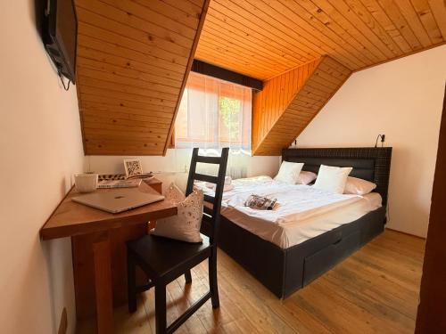 a bedroom with a bed and a desk with a laptop at Red Lake Inn in Gheorgheni