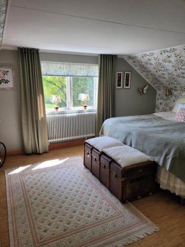 a bedroom with a bed and a large window at Linnåsen stuga in Rottneros