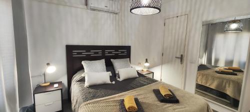 a bedroom with a large bed with towels on it at El Bungalow in Playa Fañabe
