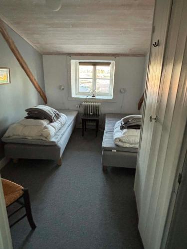 two beds in a small room with a window at Charlottenlunds Gårdshotell & Restaurang in Långaryd