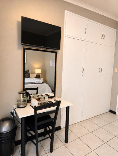 a room with a table and a bed and a mirror at Zhantique Guest House 2- Unit 4 in Boksburg