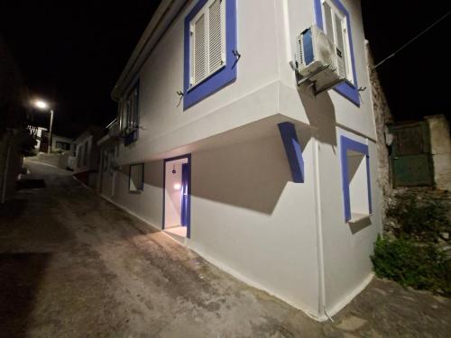 a building with blue windows and a door at night at Oikos Filon in Palaiókastron