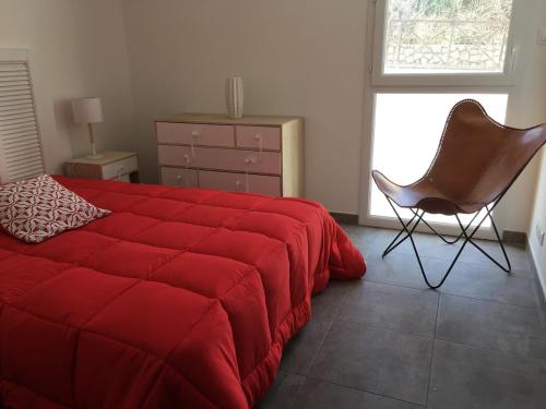 a bedroom with a red bed and a chair at Porto-Vecchio 2-bedroom apartment, pool in Porto-Vecchio