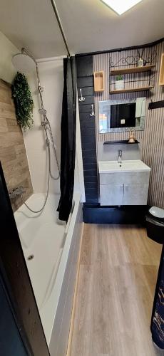 a bathroom with a tub and a sink and a shower at Le White Garden in De Panne
