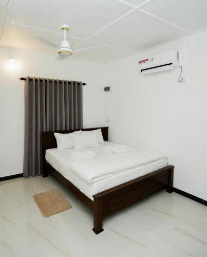 a bedroom with a bed in a white room at Villa Vianna in Nilaveli