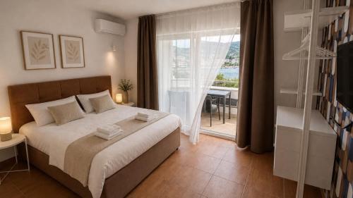 a bedroom with a bed and a window with a view at Apartments Stina & Villa Ina in Seget Vranjica