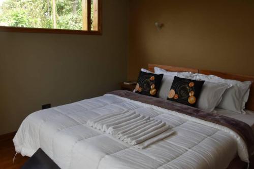 a large white bed in a bedroom with a window at Camphor Mountain View in Lushoto