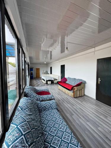 a large room with two beds and a couch at Guesthouse Snow Leopard - 'Ak Ilbirs' in Tong