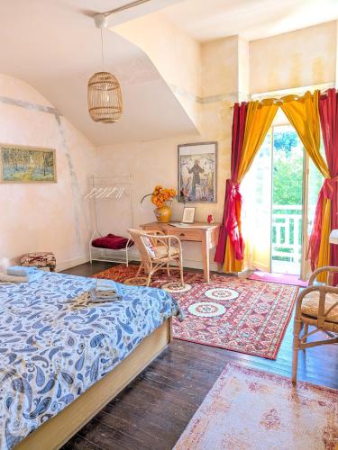 a bedroom with a bed and a table and a desk at Les Contes in Fougax-et-Barrineuf