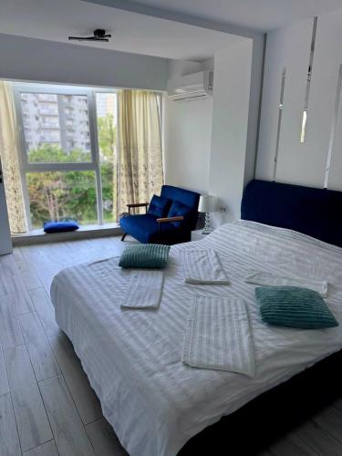 a bedroom with a large bed and a blue chair at Sea View Ani in Olimp
