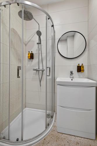 a bathroom with a shower and a sink and a mirror at Wilton House in Belfast