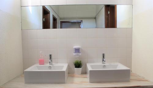 a bathroom with two sinks and a mirror at Alojamento Rural de Gouveia in Gouveia