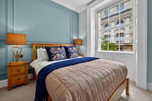 a bedroom with a bed with blue walls and a window at Wilton House in Belfast