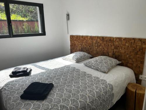 a bed with a black bag sitting on top of it at L'éphémère-Private Spa in Plérin