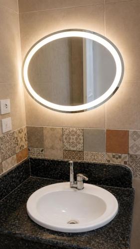 a bathroom sink with a large mirror above it at فيلا التجاريين in Dawwār ‘Abd Allāh
