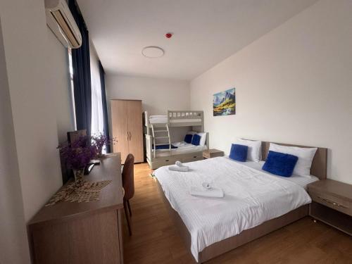 a bedroom with a large bed with blue pillows at Hotel Port Altus in Batumi