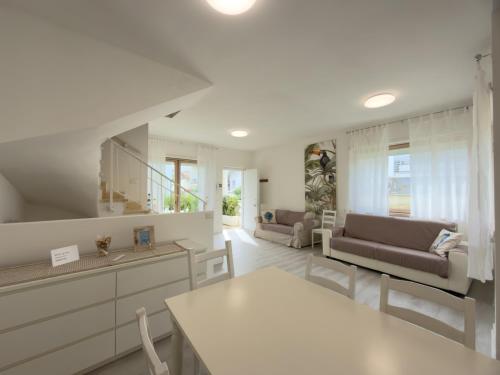 a kitchen and living room with a couch and a table at Villa Martina in Fregene