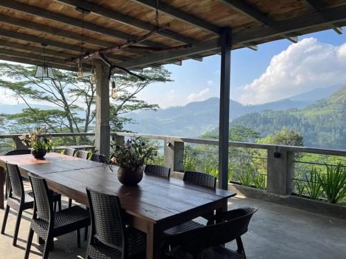 a wooden table and chairs with a view of mountains at Knuckles Retreat in Huluganga