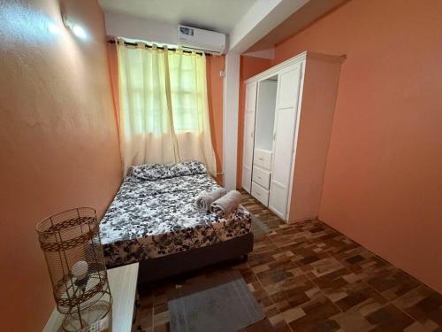 a small bedroom with a bed and a window at 2BR Guest Home - Dominica in Pointe Michel