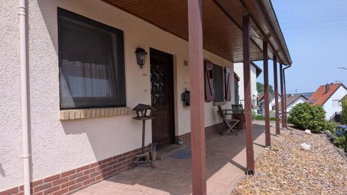 a porch of a house with a window and a door at Ferienwohnung Ella in Föckelberg