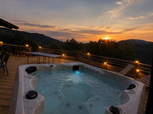 a hot tub on a deck with the sunset in the background at Charming family Chalet for 8 people, with private Hot Tub in Les Clefs