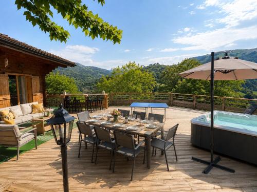 a patio with a table and an umbrella and a hot tub at Charming family Chalet for 8 people, with private Hot Tub in Les Clefs