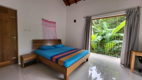 a bedroom with a bed and a large window at Parrot Paradise Negombo in Negombo
