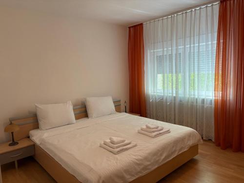 a bedroom with a bed with two towels on it at Sweet Home in Ocna-Mureşului