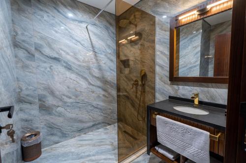 a bathroom with a sink and a mirror at Grand Babl in Erbil