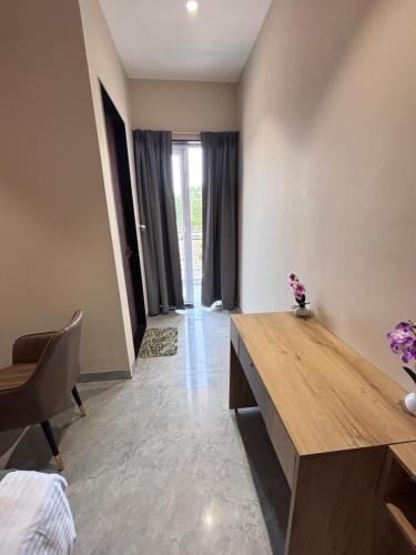 a living room with a wooden table and a chair at Hotel Stayvilla Raipur in Raipur