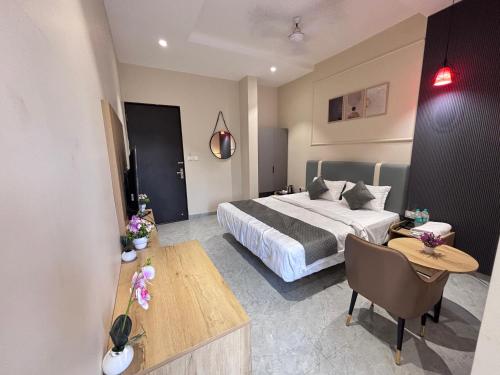 a hotel room with a bed and a table at Hotel Stayvilla Raipur in Raipur