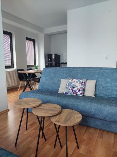 a living room with a blue couch and two tables at Villa Chaloski in Peštani