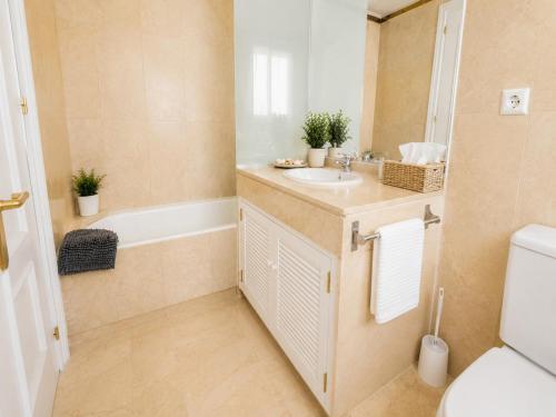 a bathroom with a sink and a tub and a toilet at Cristina Bungalow in Estepona