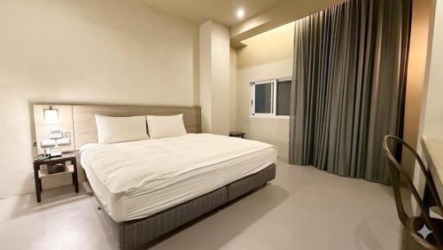 a hotel room with a bed and a window at Kiwi Express Hotel-Taichung Station II in Taichung